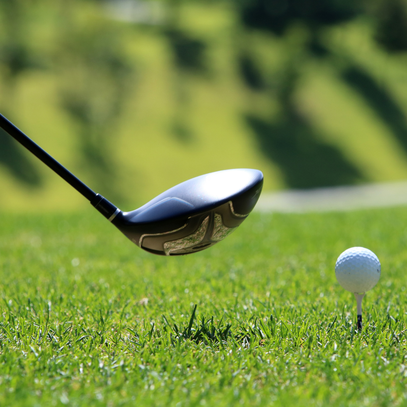 Golf ball near golf club about to take a swing